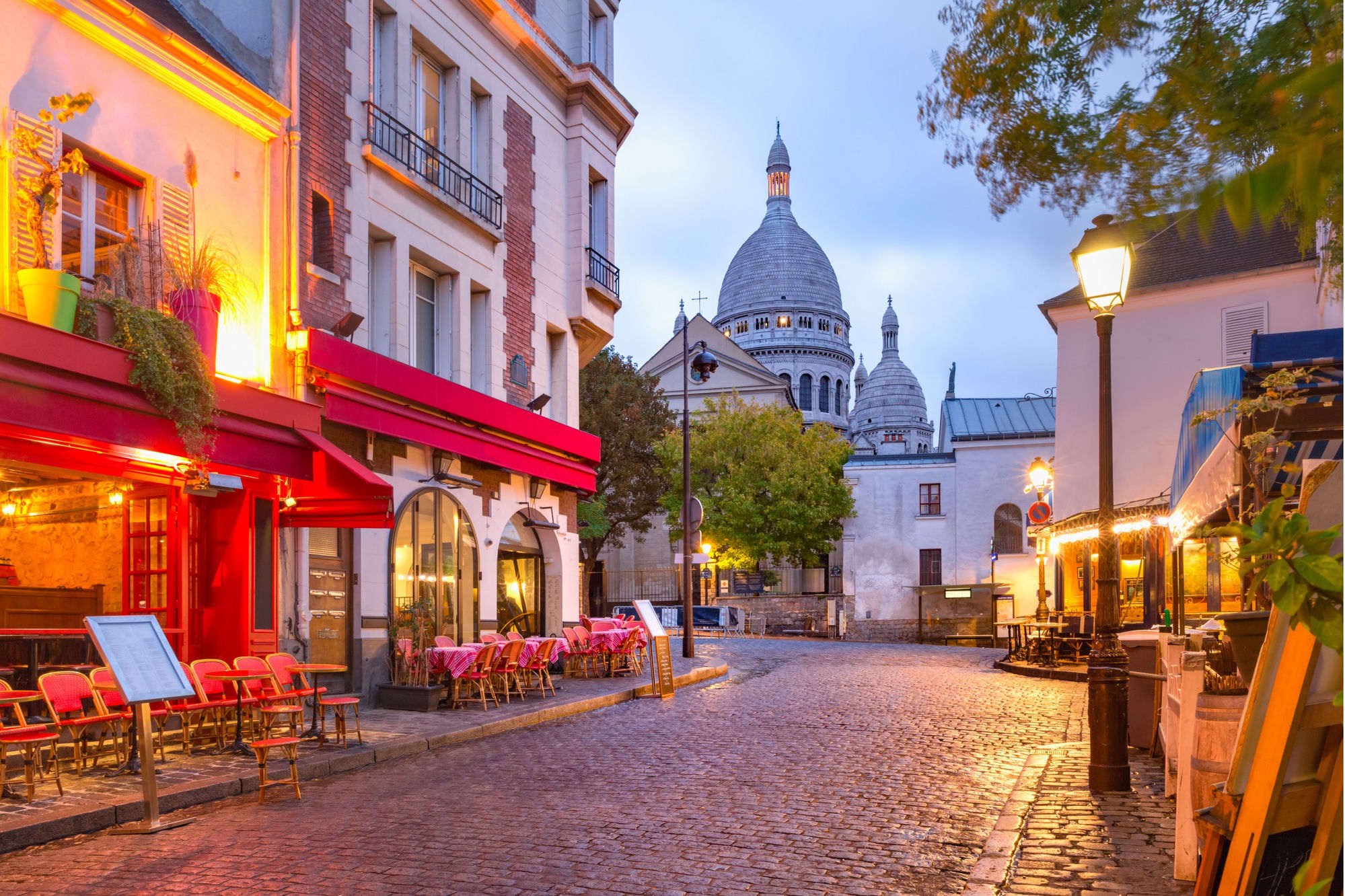 Rue pavée de Montmartre et basilique du Sacré-Cœur à Paris